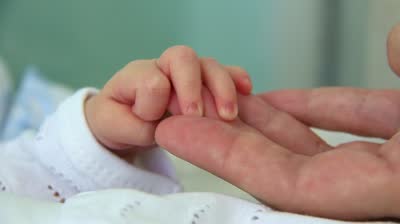 stock-footage-hand-in-hand-mother-and-newborn-daughter-in-maternity-hospital